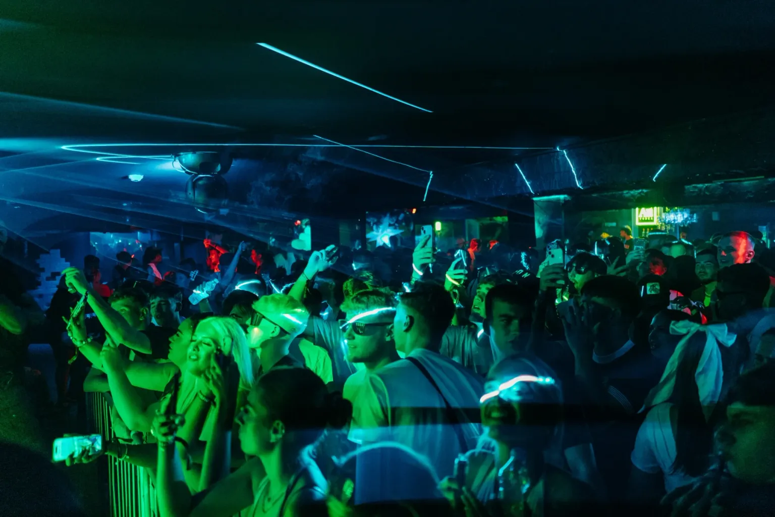 Packed club crowd dancing under green and blue lighting during the House of Tech night event in Ayia Napa