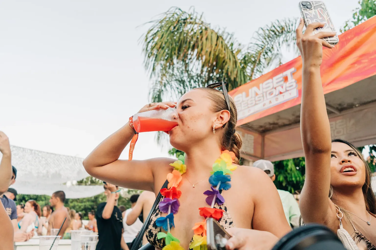 Girl drinking from a cup while partying beside the pool at Sunset Sessions Pool Party in Ayia Napa during the day