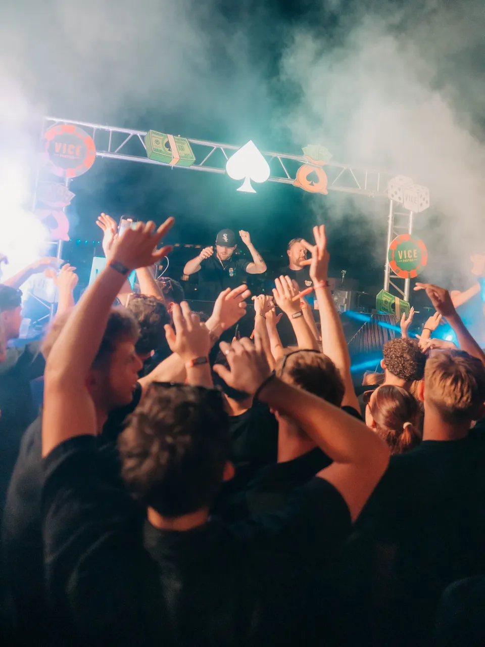 Crowd with hands raised enjoying DJs performing on stage at the Vice Rooftop Party event in Ayia Napa.