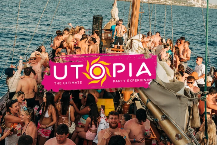 Crowded Tenerife boat party with lads and girls dancing on deck, UTOPIA banner centre stage and full daytime chaos