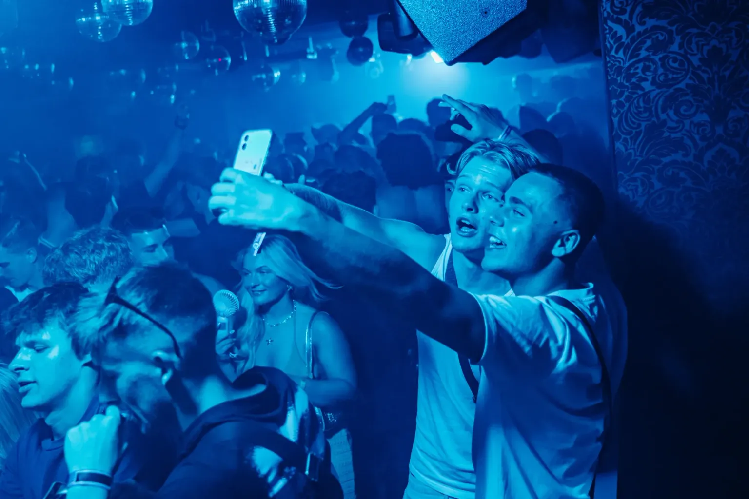 Crowd dancing under blue lights at Mansion Club Night in Magaluf
