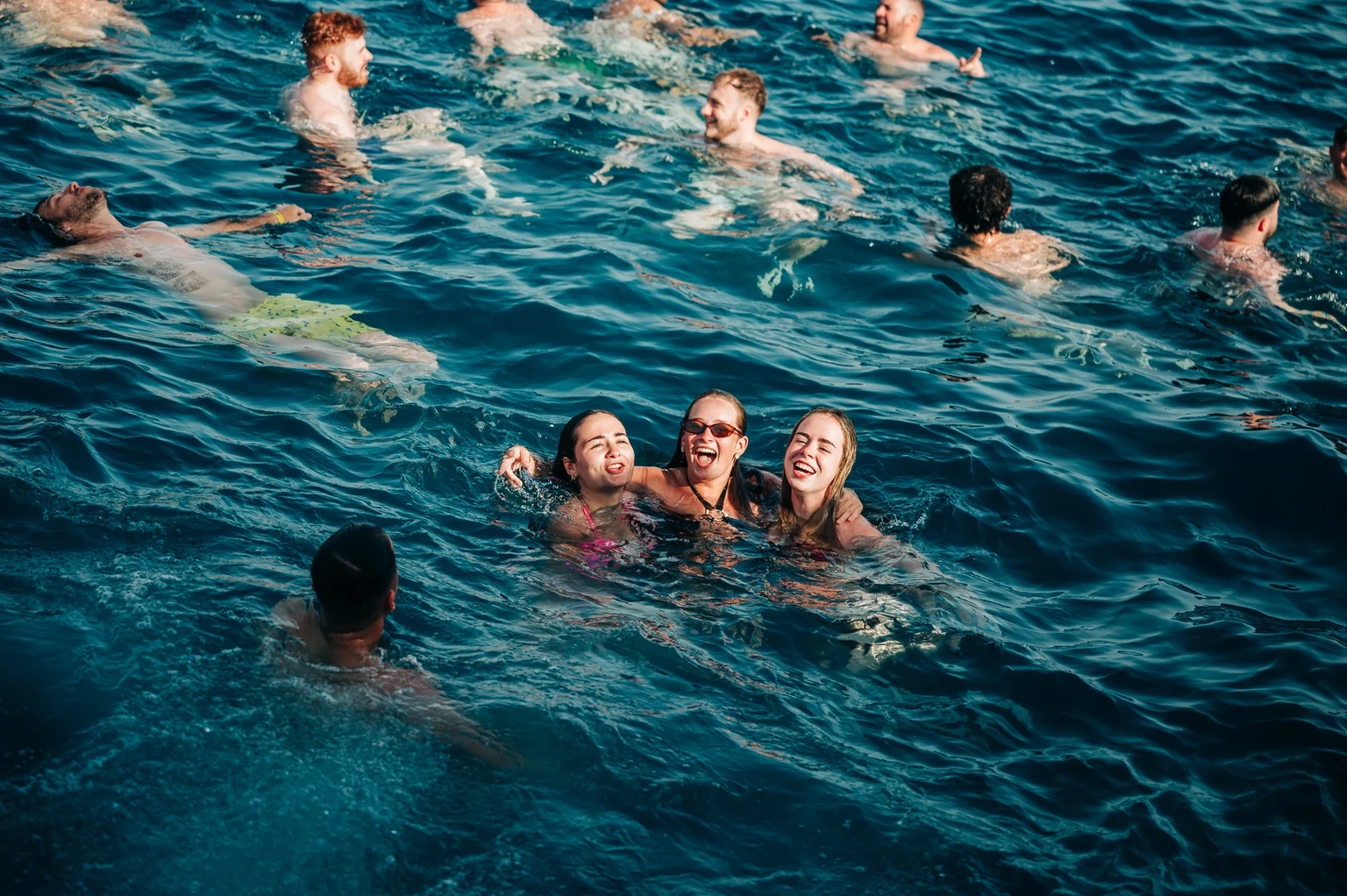 Girls cooling off in the sea during a Tenerife boat party, laughing together as the swim break keeps the vibes high