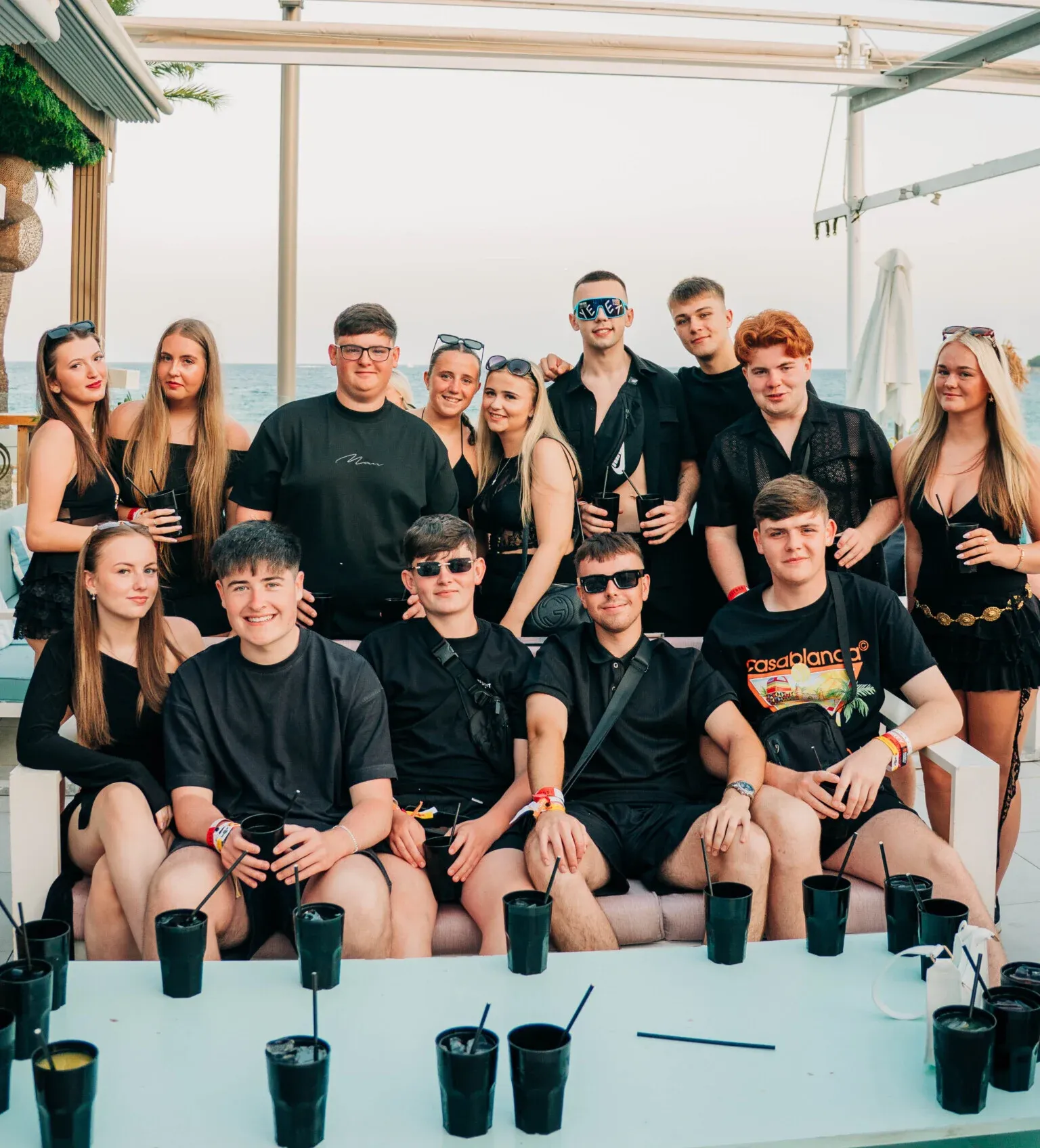 Large group dressed in black posing together at Agenda Beach Club Party in Magaluf