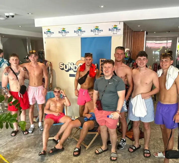 Group of lads posing at Bora Bora Sundown Malta pool party with shorts, drinks and full summer party vibes