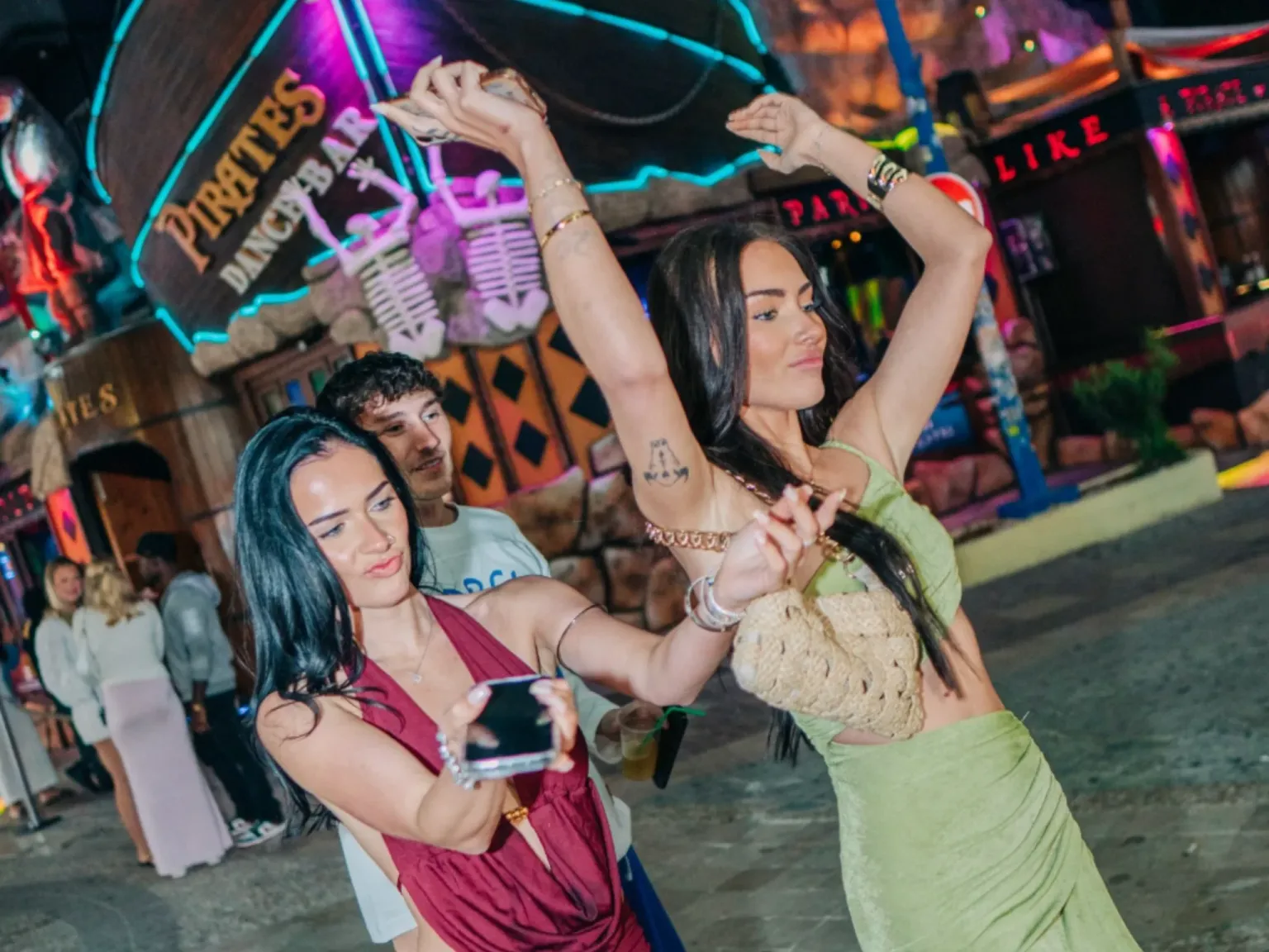 Pirates Bar Ayia Napa outside street view with two girls dancing walking past it