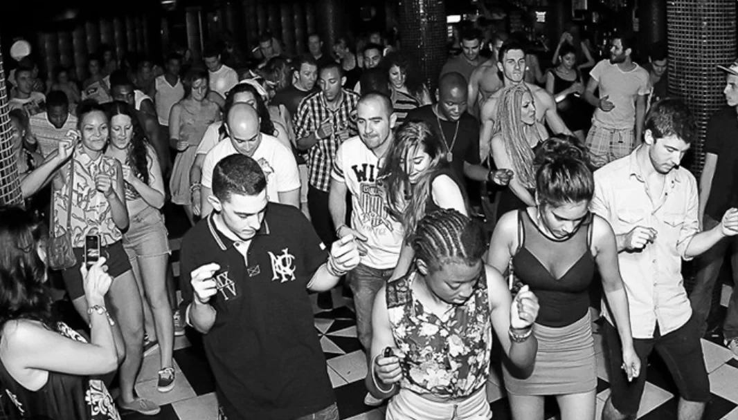 Black and White Club Ayia Napa, inside view of guests dancing with a black and white filter