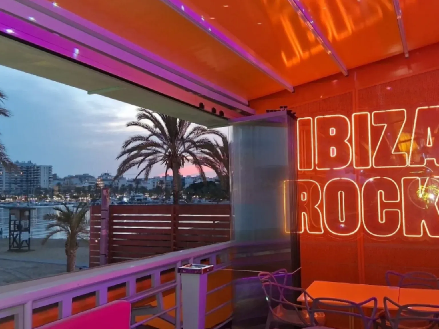 Ibiza Rocks Bar inside view with palm tree in the background and neon lights