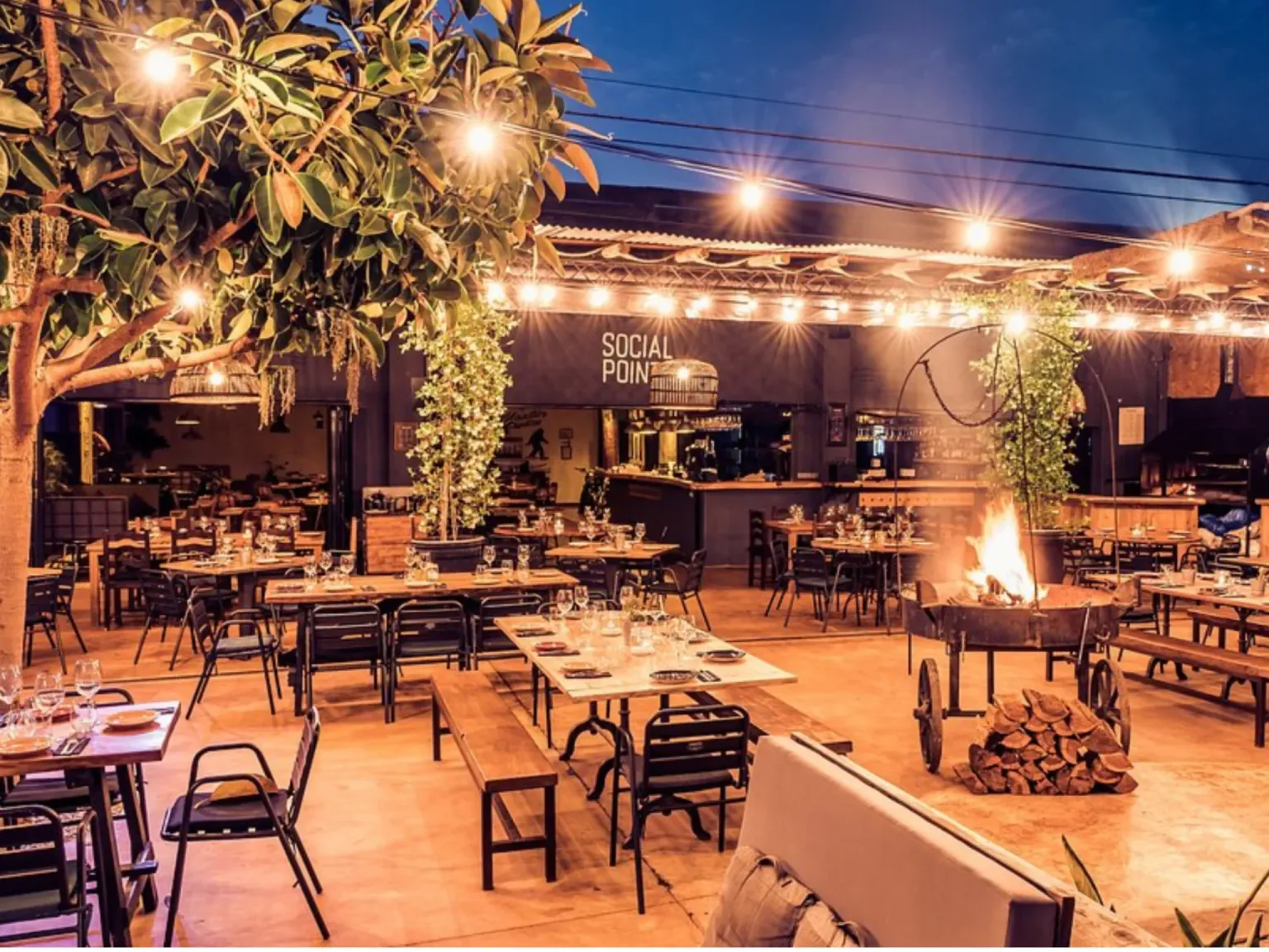 The Social Bar Ibiza outdoor seating area with dim lights and plants