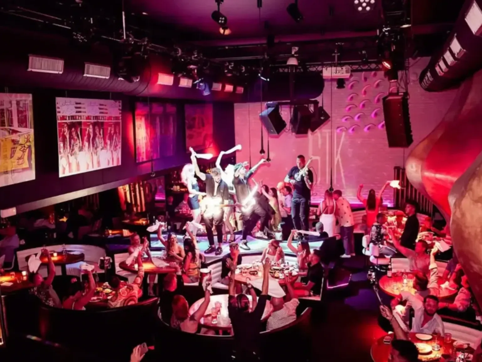 STK Ibiza Bar artists dancing on tables with pink lighting