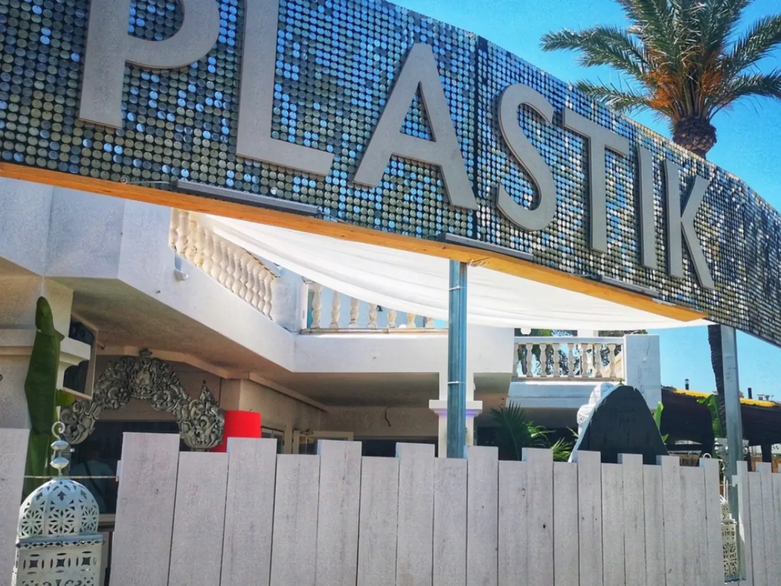Platik Bar Ibiza Street View of sparkly sign with palm tree in the background