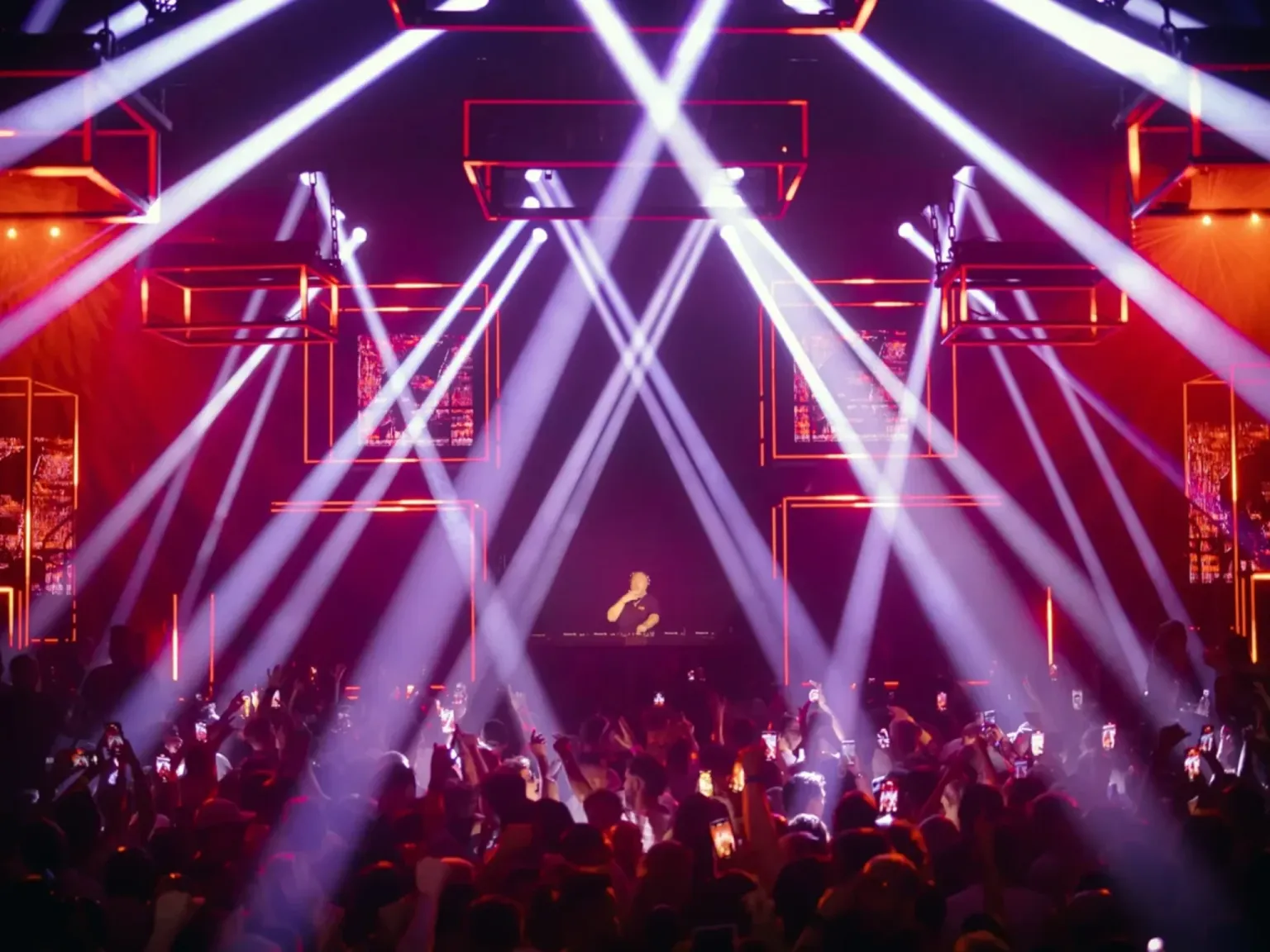 Hi Ibiza Glitterbox big rave vibes with purple and red lighting and a centre DK with crowds with their hands in the air dancing