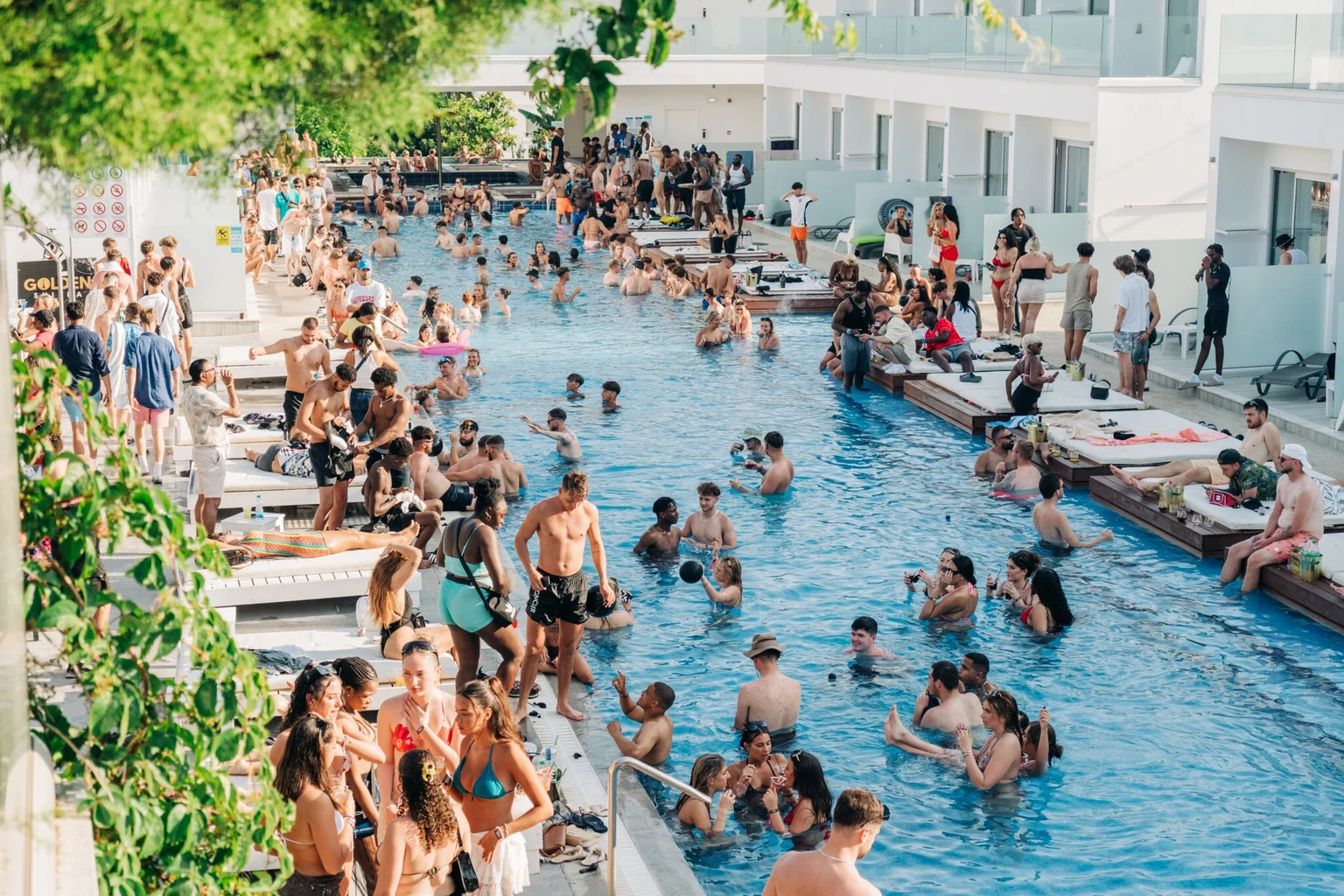 Partygoers filling the swimming pool and poolside area at Sunset Sessions Pool Party in Ayia Napa during the day