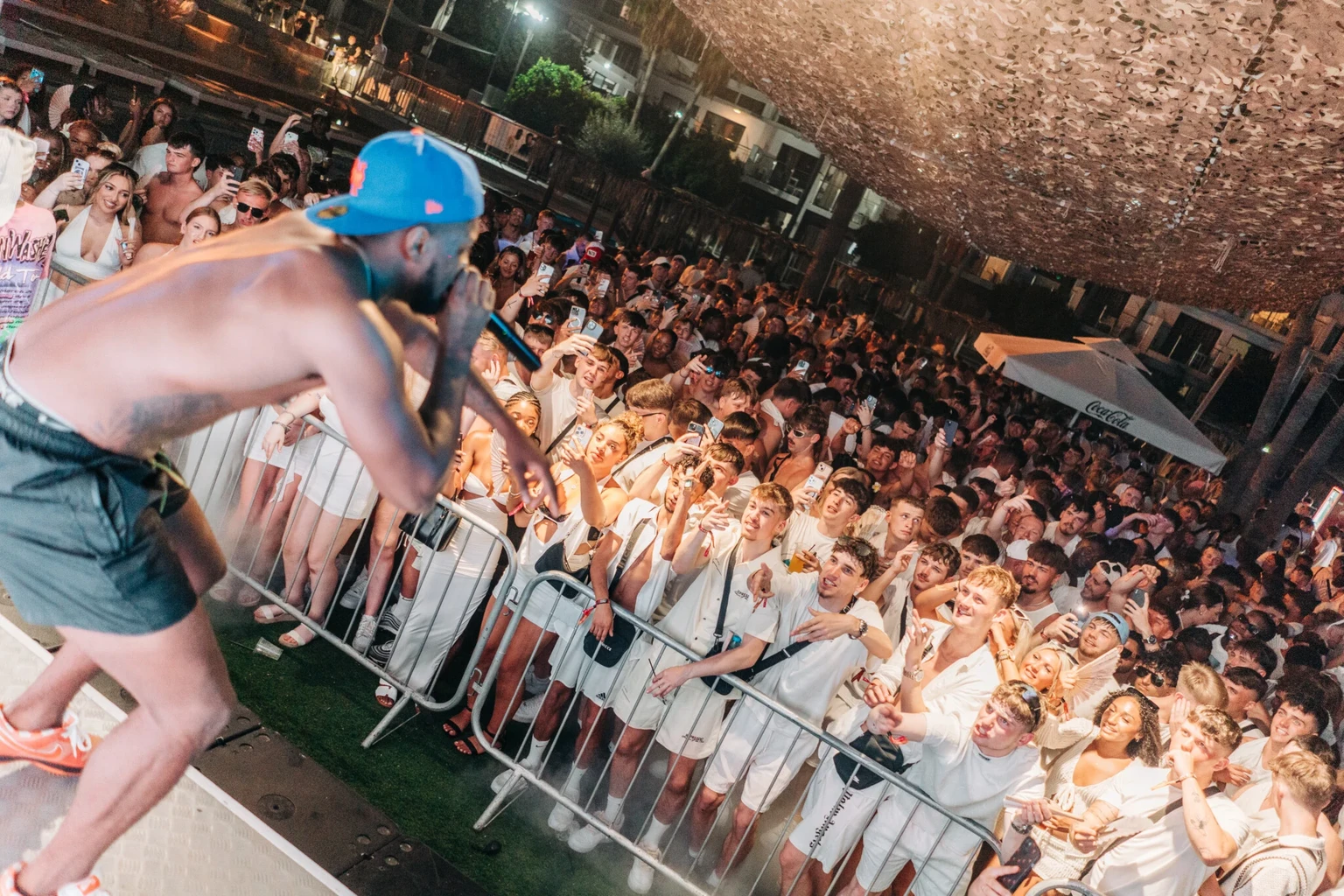Live performer Swarmz on stage in front of a packed crowd dressed in white at the Agenda White Party in Ayia Napa