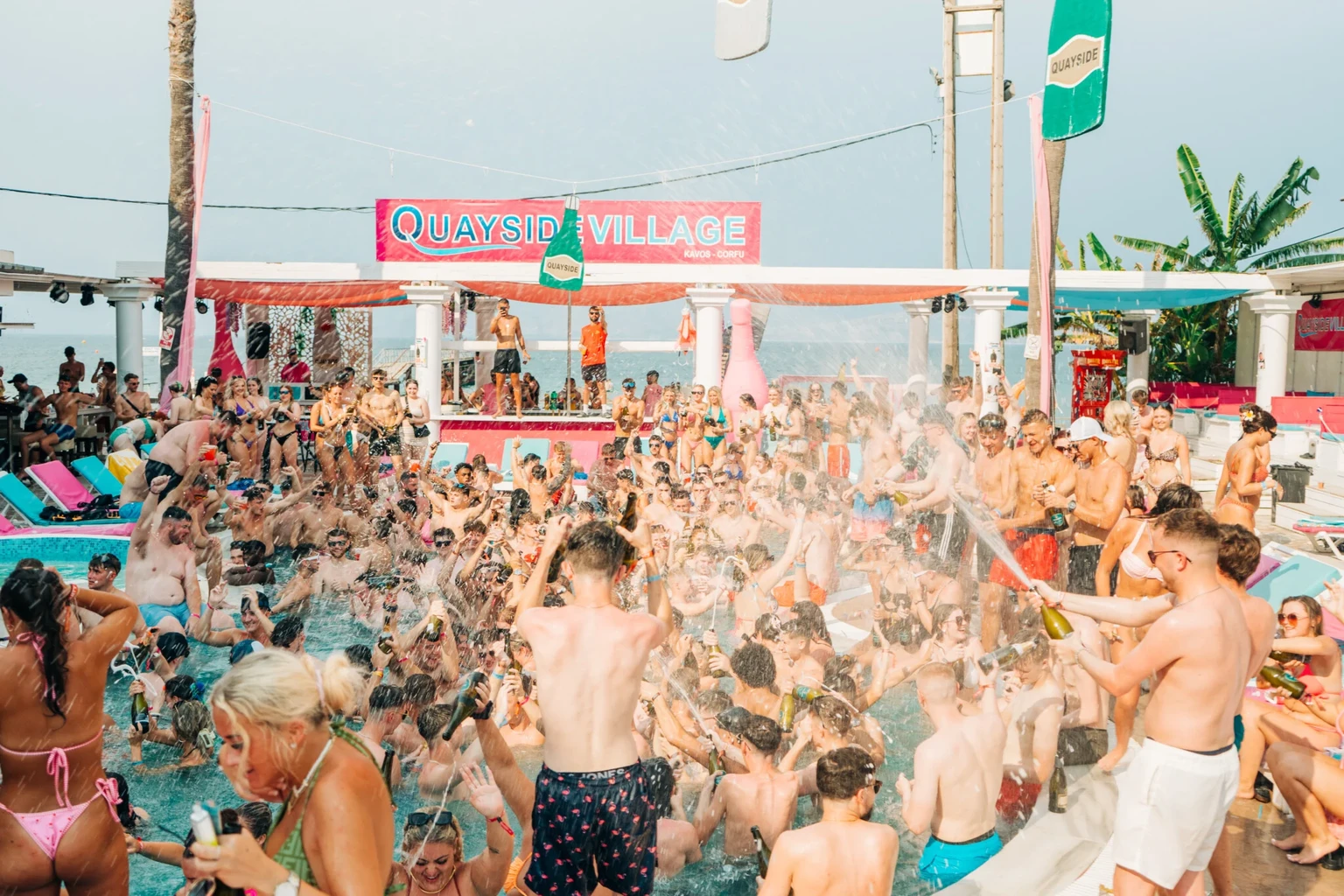 Crowd dancing around the pool at Champagne Sessions in Kavos