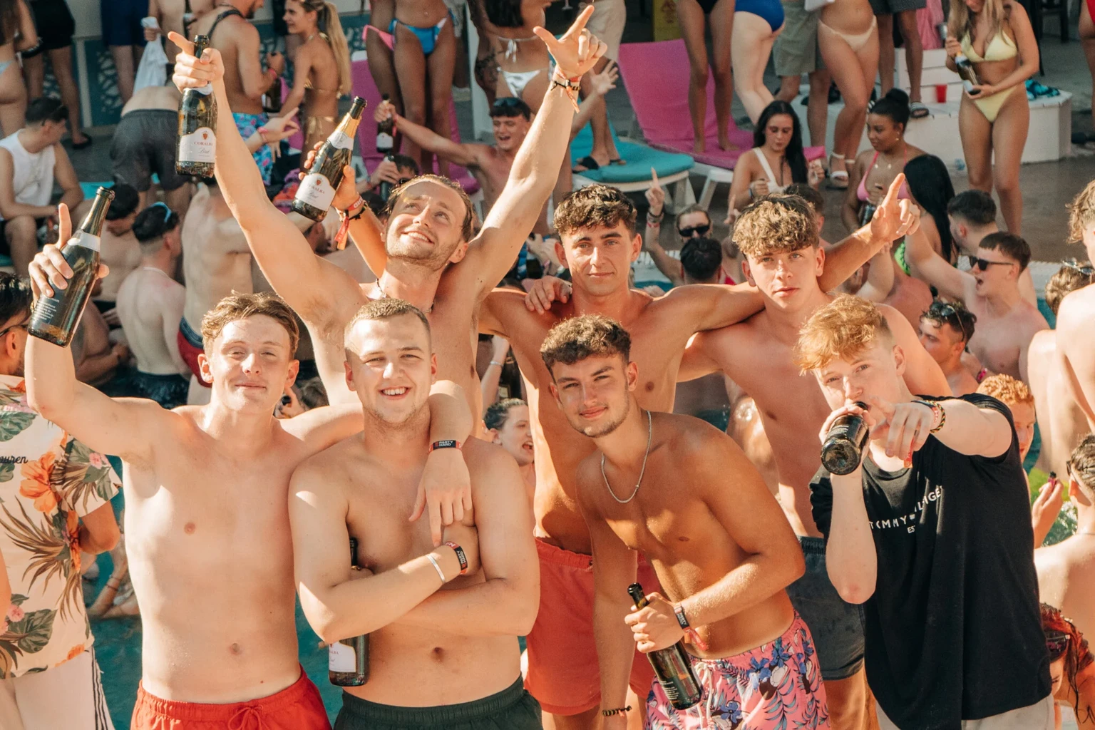 Partygoers with hands raised at Champagne Sessions Pool Party in Kavos