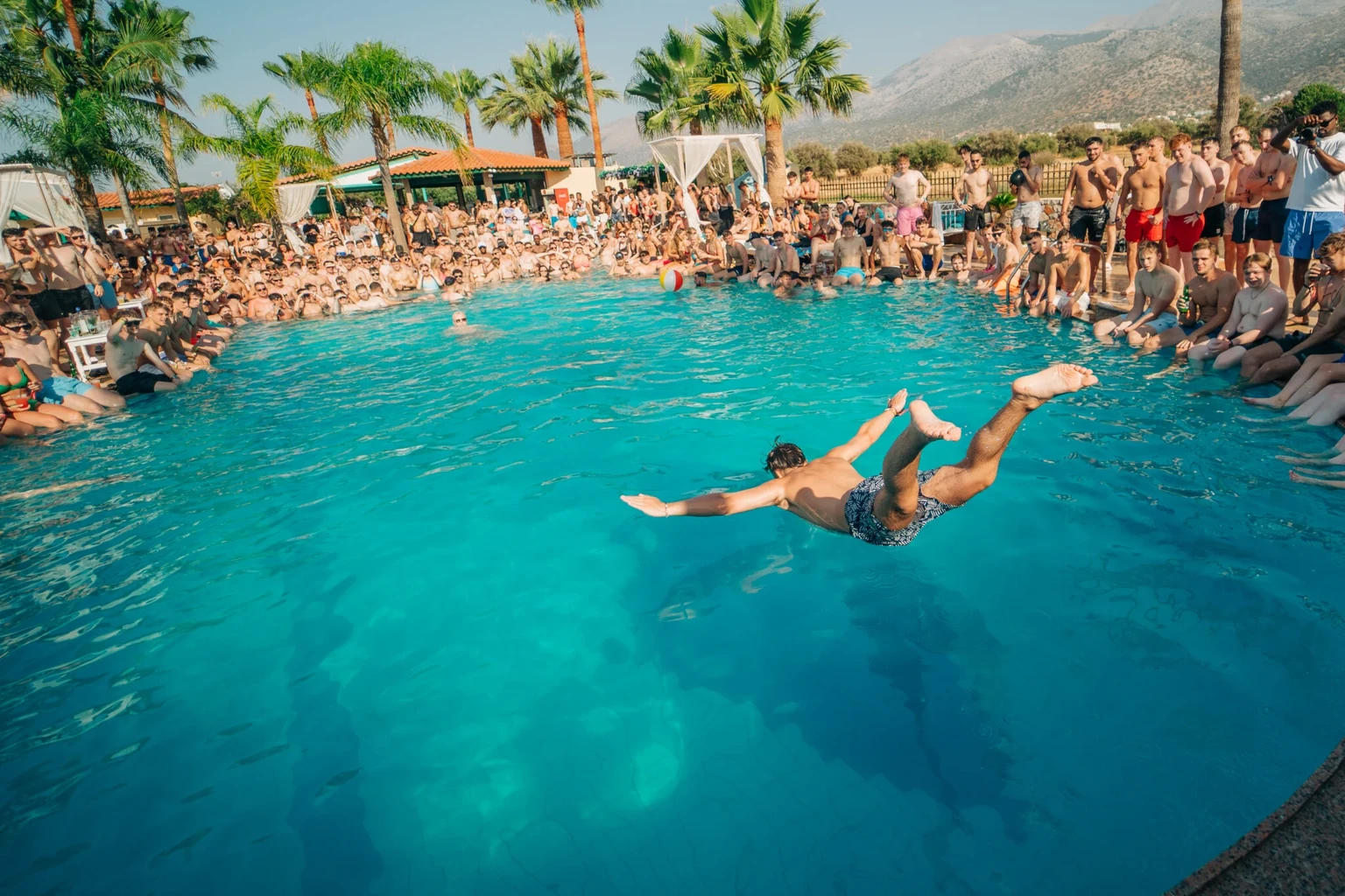 Lad jumping into the pool during a Malia pool party